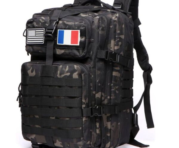 Camouflage tactical backpack with MOLLE straps and patches showing US and French flags, multiple compartments.