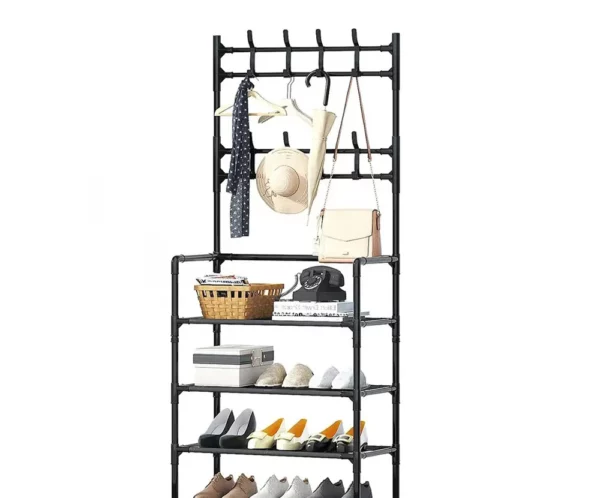 A freestanding black multi-tier clothing rack with hangers, hats, bags, and scarves hanging on top shelves and several pairs of shoes on the lower shelves.