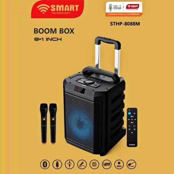 Portable Bluetooth boom box with a blue-lit front speaker, carrying handle, two wireless mics, and a tall remote on a yellow background (SHTP-8088M).