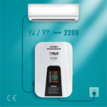 Air conditioner connected to a white automatic voltage regulator mounted on a teal wall, with 220V output shown between them, and a power cord plugged in at the bottom left.",