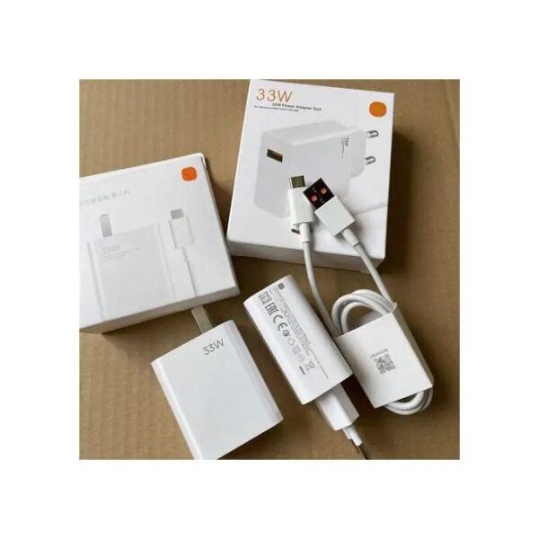 White 33W USB-C power adapter kit with cable and packaging on a cardboard surface, unboxed and arranged neatly.