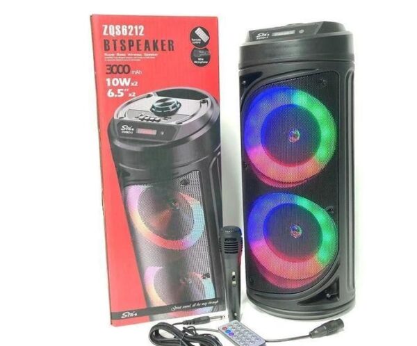Portable Bluetooth speaker with rainbow LED ring lights, shown beside its box, remote, and power cable.