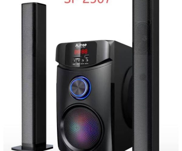 Speaker system with a central subwoofer and two tall, perforated black satellite speakers, model SP 2507, with colorful LED-lit woofer