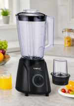 Black Campus USA blender with large transparent pitcher and lid on a kitchen counter; juice and fruit nearby, plus a separate blending cup on the side.