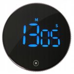 Close-up of a black circular dial with blue glowing text and numbers along the bottom edge, partially cropped edge visible.