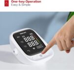 Finger pressing the Start/Stop button on a digital blood pressure monitor with a black display showing systolic/diastolic readings and color risk bar.