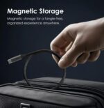 Close-up of a hand holding a braided USB-C cable above a suitcase, with 'Magnetic Storage' text on a dark background.