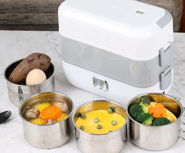 White electric lunch box on a marble counter surrounded by five stainless steel food containers with mixed meals like corn, broccoli, and vegetables.