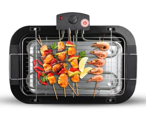 Electric grill with skewers of chicken, shrimp, peppers, parsley, and lemon wedges on the rack